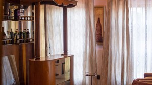 A room with a wooden bar area, a mirror, and a window with sheer curtains. - Afranasa Inn (Tema)