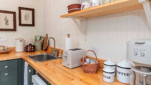 A kitchen with a wooden countertop, a toaster, a coffee maker, and labeled containers for sugar and coffee. - Stay Vintage at Dandelion (McKinney)