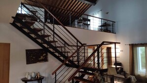 Una escalera de varios niveles con barandillas de madera y soportes de metal, que conduce a un piso superior.