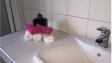 Chuveiro, secador de cabelo, bidê, toalhas de banho