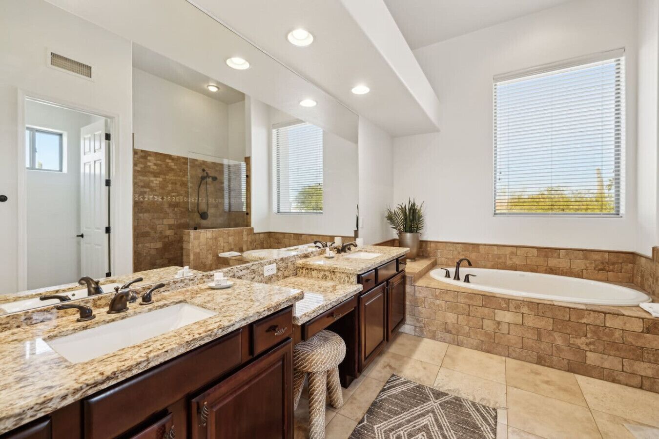 A modern bathroom with a large vanity, a separate bathtub, and a walk-in shower.
