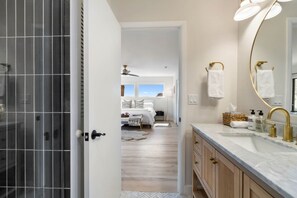 A modern bathroom with a large mirror, gold fixtures, and a view into a bedroom. - Redscape, Near Great Hiking, Views, Hot Tub, Firepit-Charming Design (Sedona)