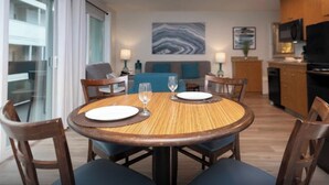 Un coin repas avec une table ronde, des chaises et une vue sur la cuisine et le salon.