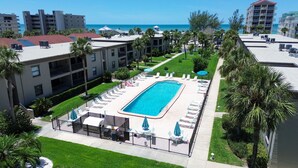 Ein Hotel mit Swimmingpool, Liegestühlen und Blick aufs Meer.