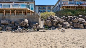 Et hotel ved stranden med moderne design, der har en markant balkon og havudsigt.