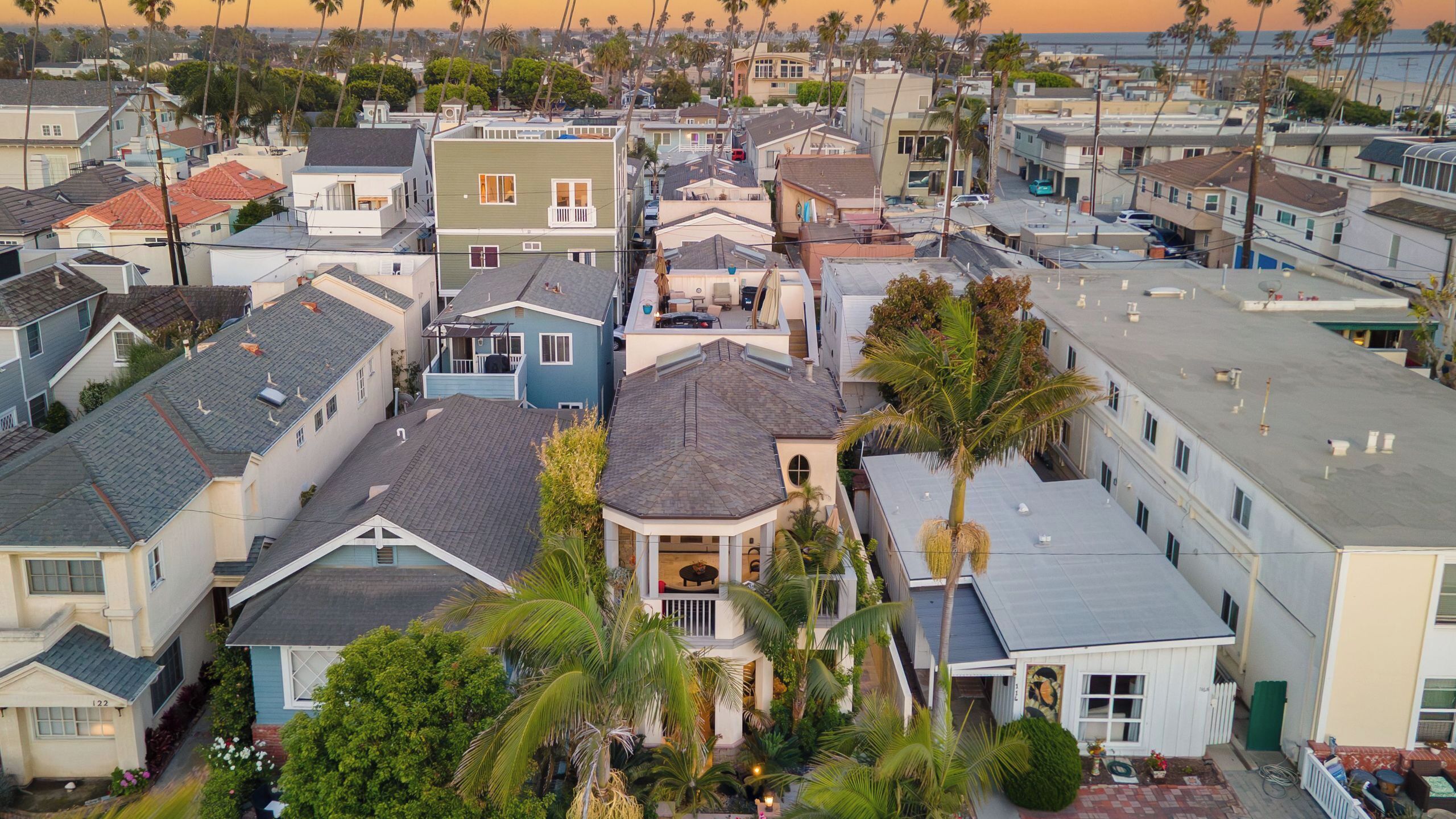 A residential area with multiple houses, some with visible balconies and a central house with a distinctive bay window.