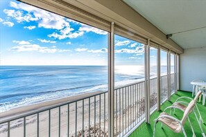 A balcony with a view of the ocean, a table, and two chairs. - English Towers-Picturesque Ocean Views in this 2 Bedroom Condo with Indoor Pool! (Ocean City)