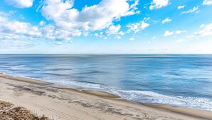 A beach with a clear sky and calm sea.