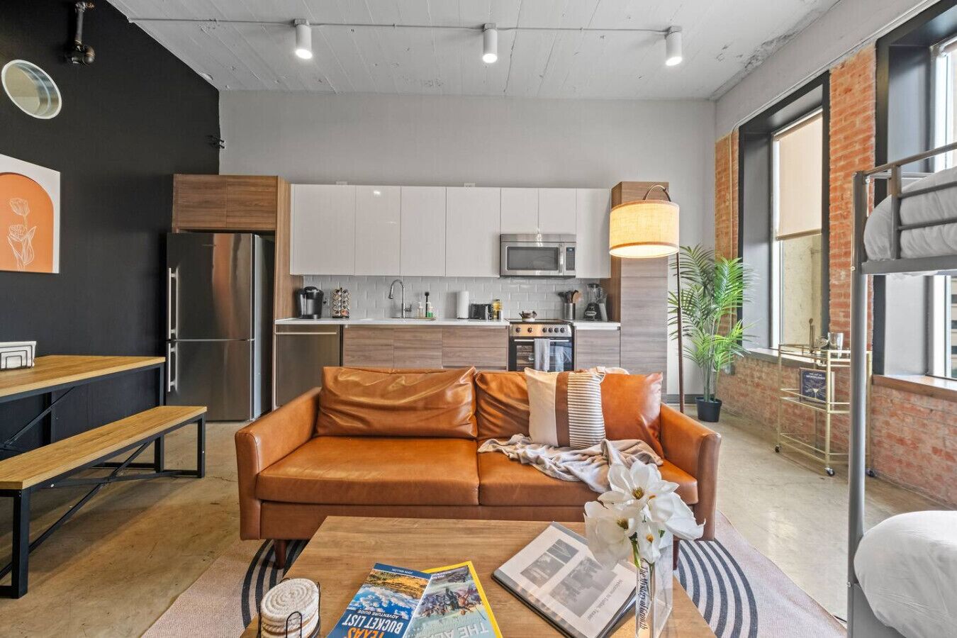 Comfortable studio with sofa, kitchen, dining table, and bunk bed for a relaxed stay.