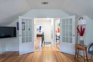 An open door leading to a room with a bed, a desk, and a chair. - 7BR The Athena! Luxury Chef's Kitchen in Montrose ★★★★★ (Houston)
