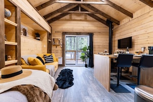 Un interior de cabaña acogedor con detalles de madera, una zona de comedor y un espacio de estar confortable.