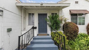 A house with a dark blue door, white exterior walls, a small porch, and a black metal railing. - 10mins to Rodeo Drive, 15mins to Venice Modern 4bdr Shenandoah by Avantstay (Los Angeles)