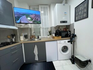 A compact kitchen with a washing machine, a microwave, and a sink. - 1-Joli appartement quartier saint-Anne, Reims (Reims)