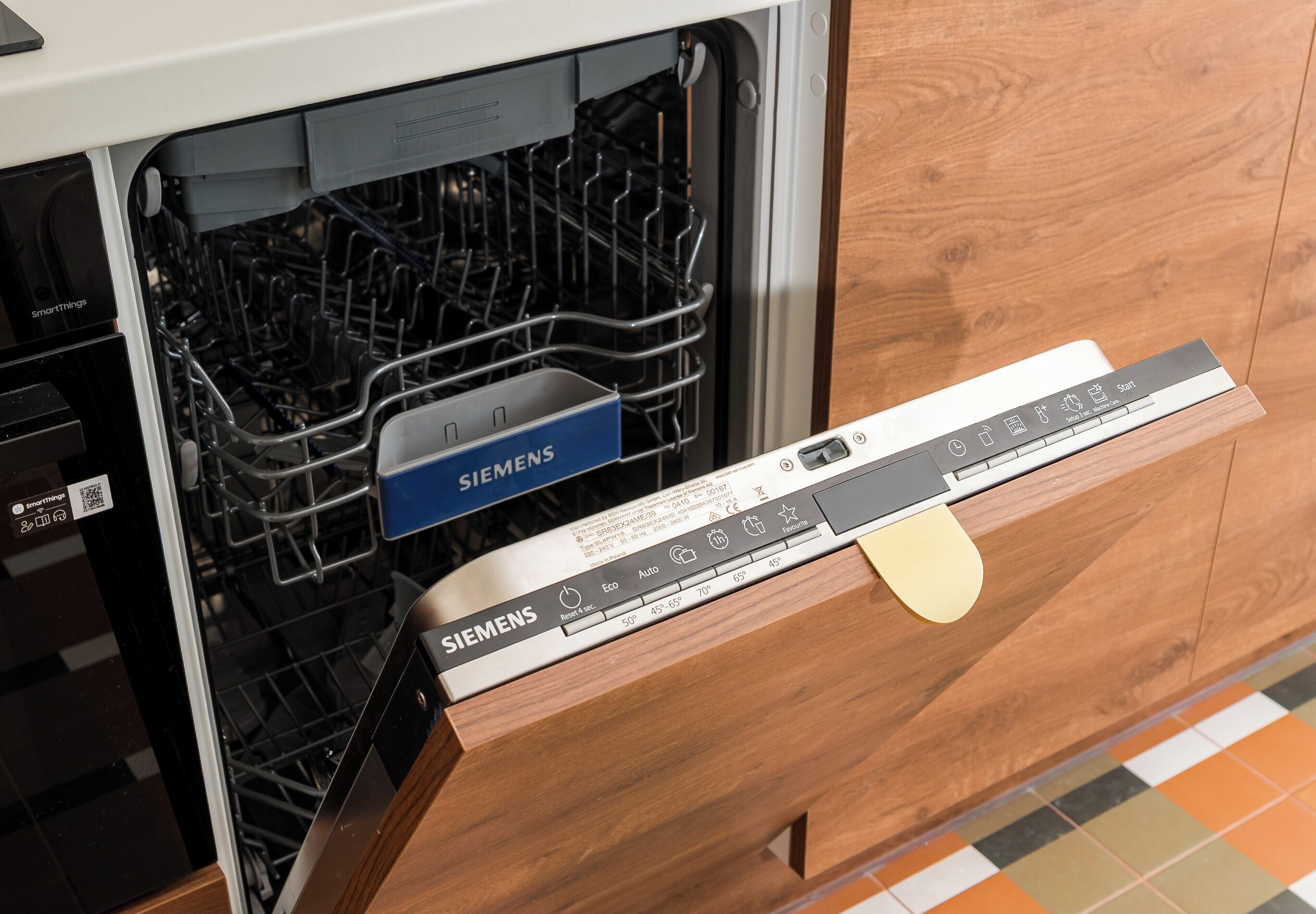 Una lavastoviglie Siemens installata in una cucina con mobili in legno.