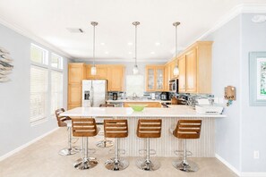 A modern kitchen with a central island, bar stools, and pendant lighting. - Private Florida Keys Escape w/ Pool, Dock, Tiki Bar – Pet Friendly (Little Torch Key)