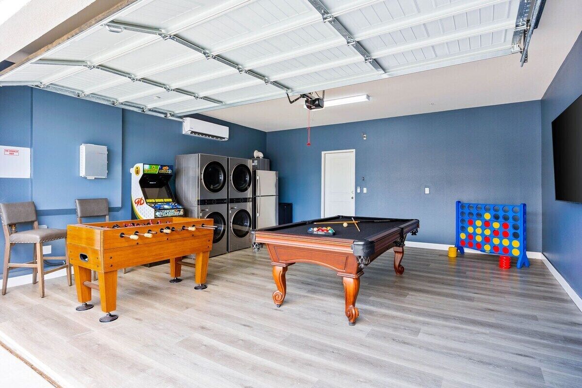 Une salle de loisirs équipée d’un baby-foot, d’une table de billard et d’un flipper.