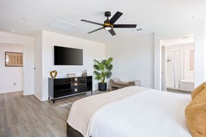 A modern bedroom with a bed, a TV, a ceiling fan, a plant, and a walk-in closet. - Margaritaville | Pickleball, Pool+Spa, GameRoom! (Coachella)