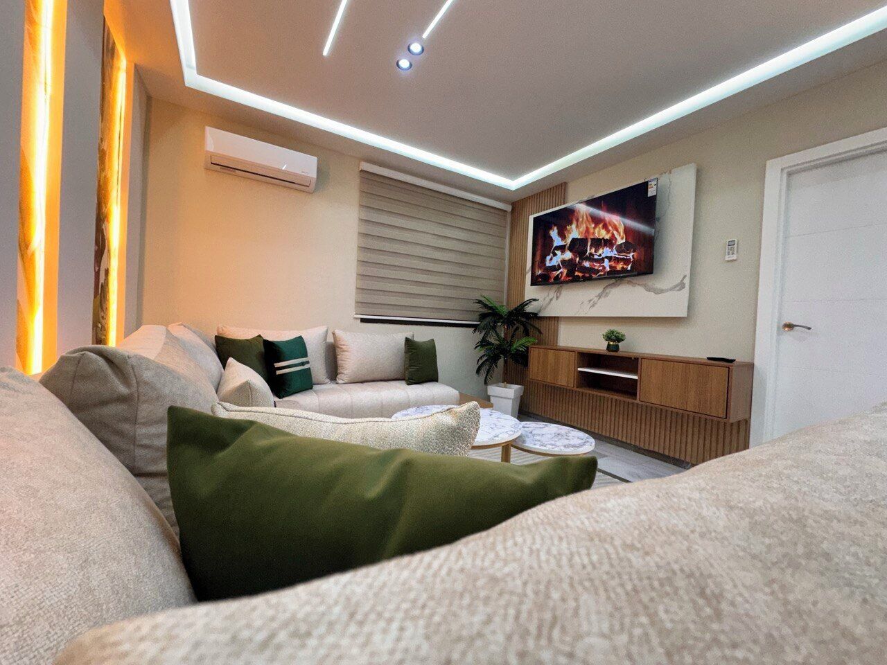 Un soggiorno moderno con un divano, un tavolino da caffè e una TV a parete.