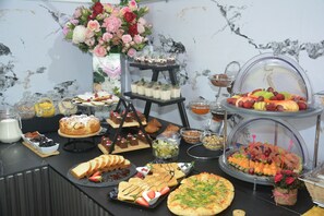 A buffet with various food items, including desserts, fruits, and pastries. - Hotel Tommy (Budva)