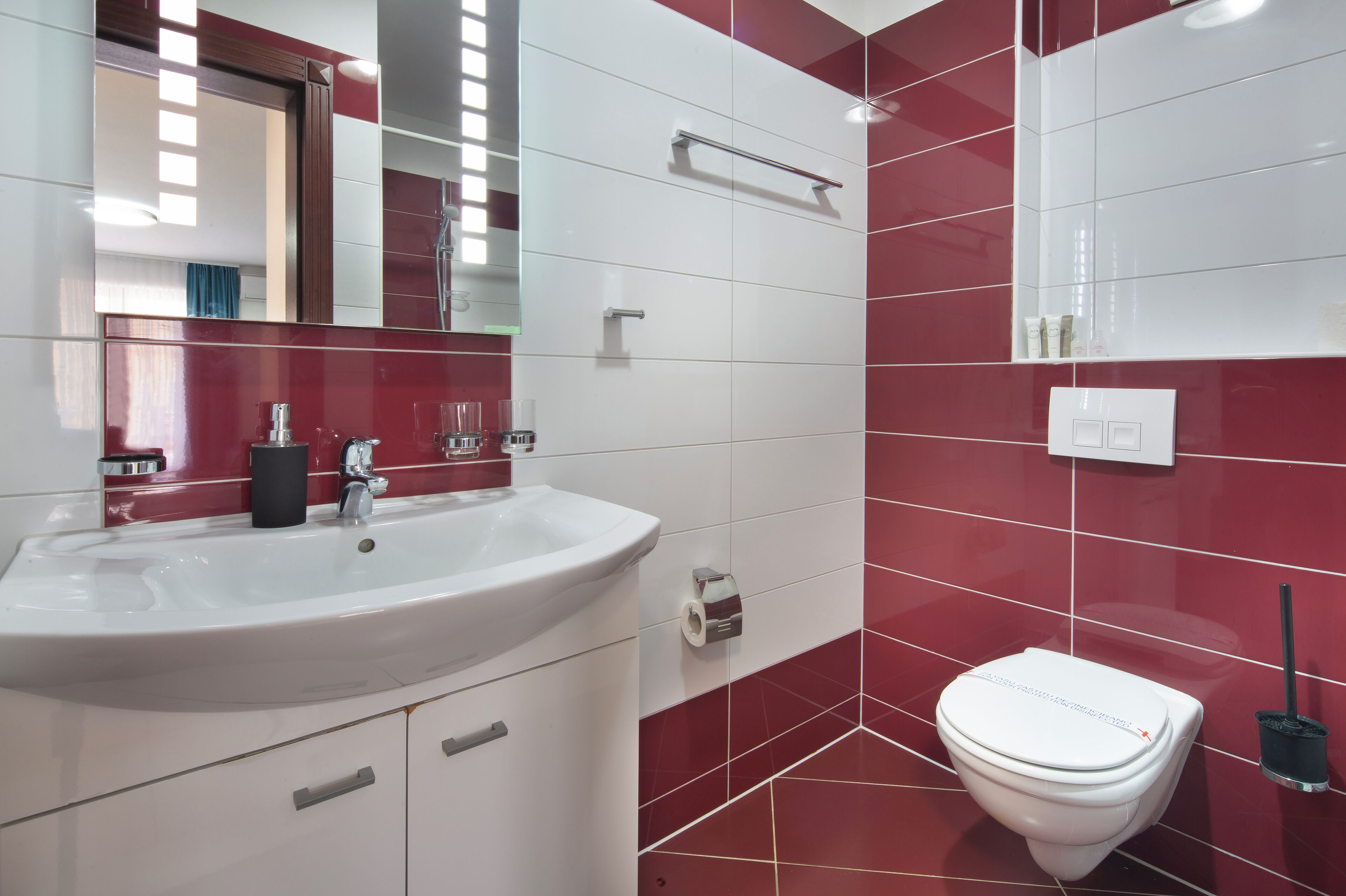 Une salle de bain moderne avec un lavabo blanc, des toilettes et un miroir.