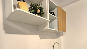 A modern kitchen with a gas stove, a sink, and wooden cabinets. - Apartamento cerca a la playa Punta Roca (Puerto Colombia)