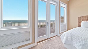 A bedroom with a large window overlooking a beach and a balcony. - LARGE PRIVATE HOME FOR THE PERFECT VACATION! (Gulf Shores)