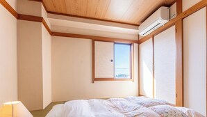 Una habitación con una cama, una ventana y un equipo de aire acondicionado.