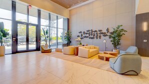 A spacious lobby with large windows, modern seating, and a decorative wall. - Oceanview 2BR/2BA in Miami Beach + Beach Club 1408RP (Miami Beach)