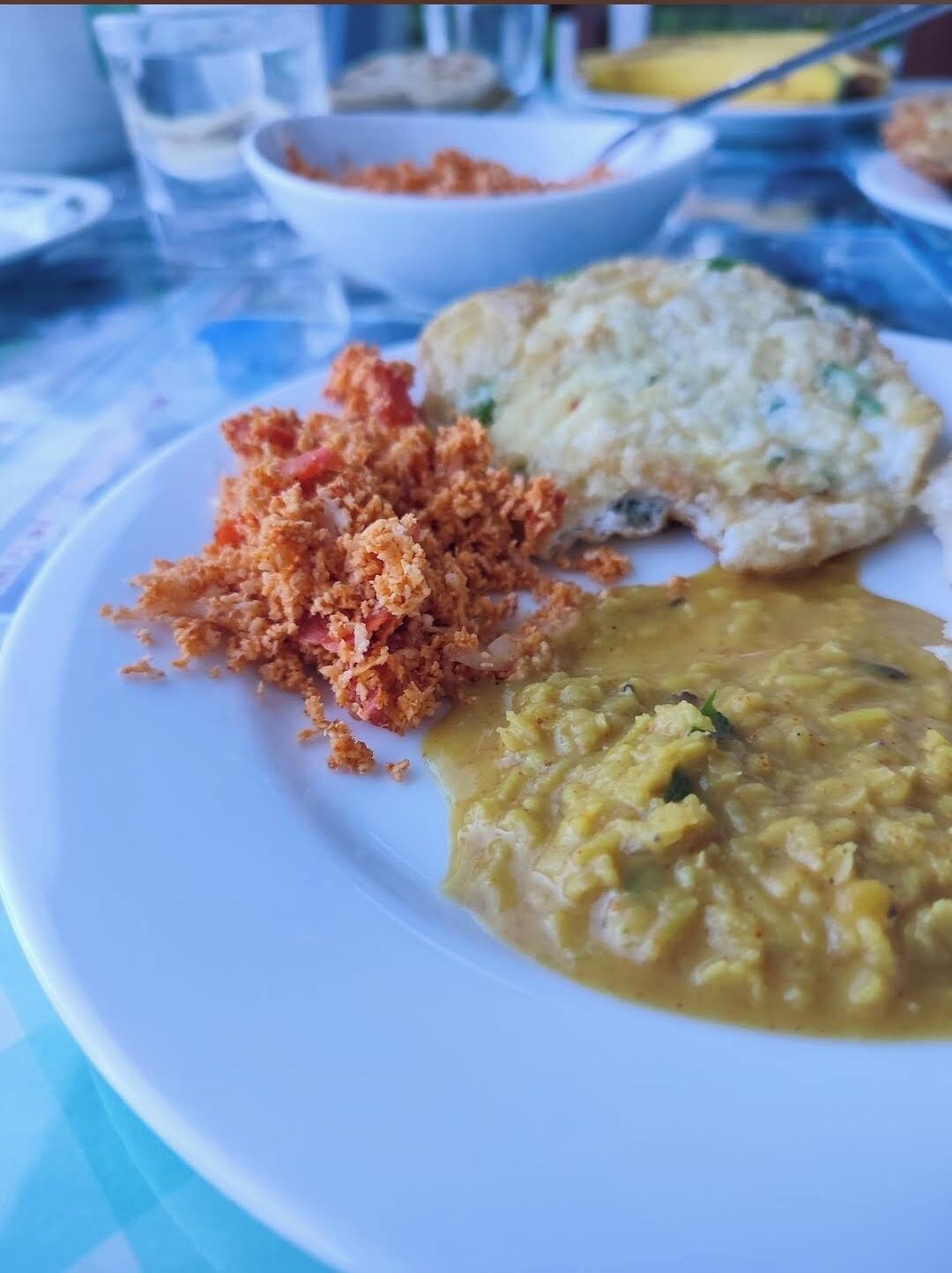 Un plato con alimentos, incluyendo un plato empanizado, una sopa cremosa y una guarnición que parece ser de papa.