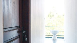 A wooden door with a keyhole and a white pedestal with a bowl on a balcony. - Duet hearts (Ella)