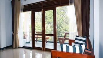 A room with a sliding glass door leading to an outdoor patio area with a wooden table and chairs.
