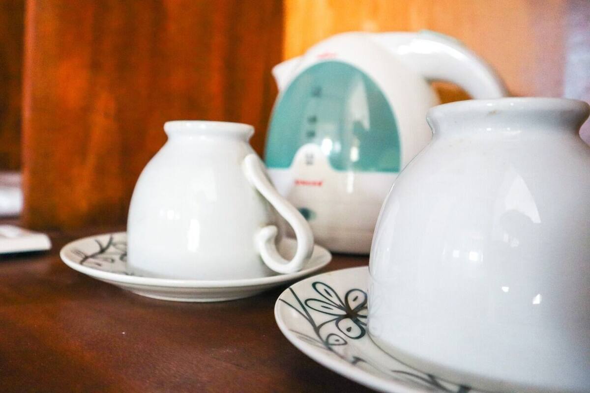 A table with a teapot, a teacup, and a saucer.