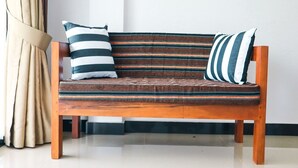A wooden sofa with striped cushions and a matching throw blanket. - Duet hearts (Ella)