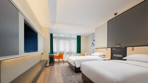 Une chambre d’hôtel avec deux lits, un bureau, une chaise et une télévision.
