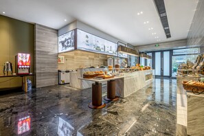 A modern hotel lobby with a marble floor, a reception desk, a digital screen, and a large window offering a view of the outdoors. - Madison Hotel Yangzhou East High-speed Railway Sta (Yangzhou)