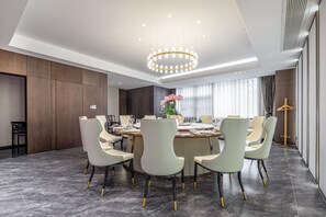 A modern dining room with a round table, six chairs, and a chandelier. - Madison Hotel Yangzhou East High-speed Railway Sta (Yangzhou)