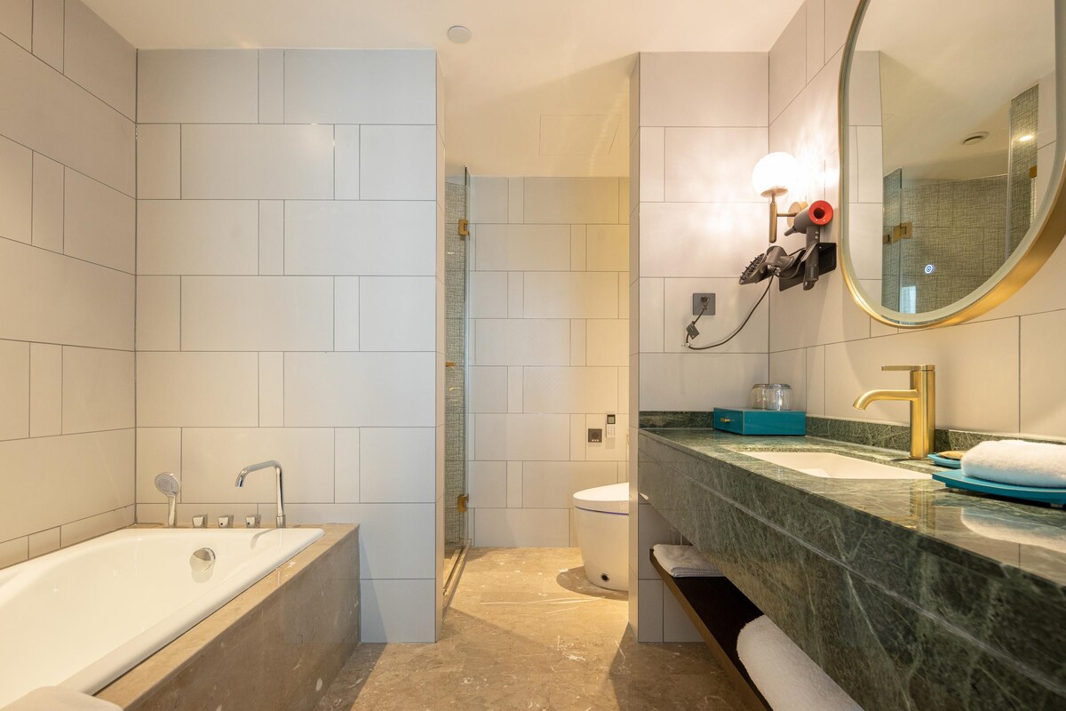 A modern bathroom with a bathtub, a sink, and a toilet.