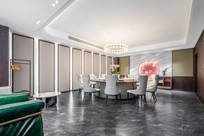 A modern dining area with a round table, grey chairs, and a chandelier. - Madison Hotel Yangzhou East High-speed Railway Sta (Yangzhou)