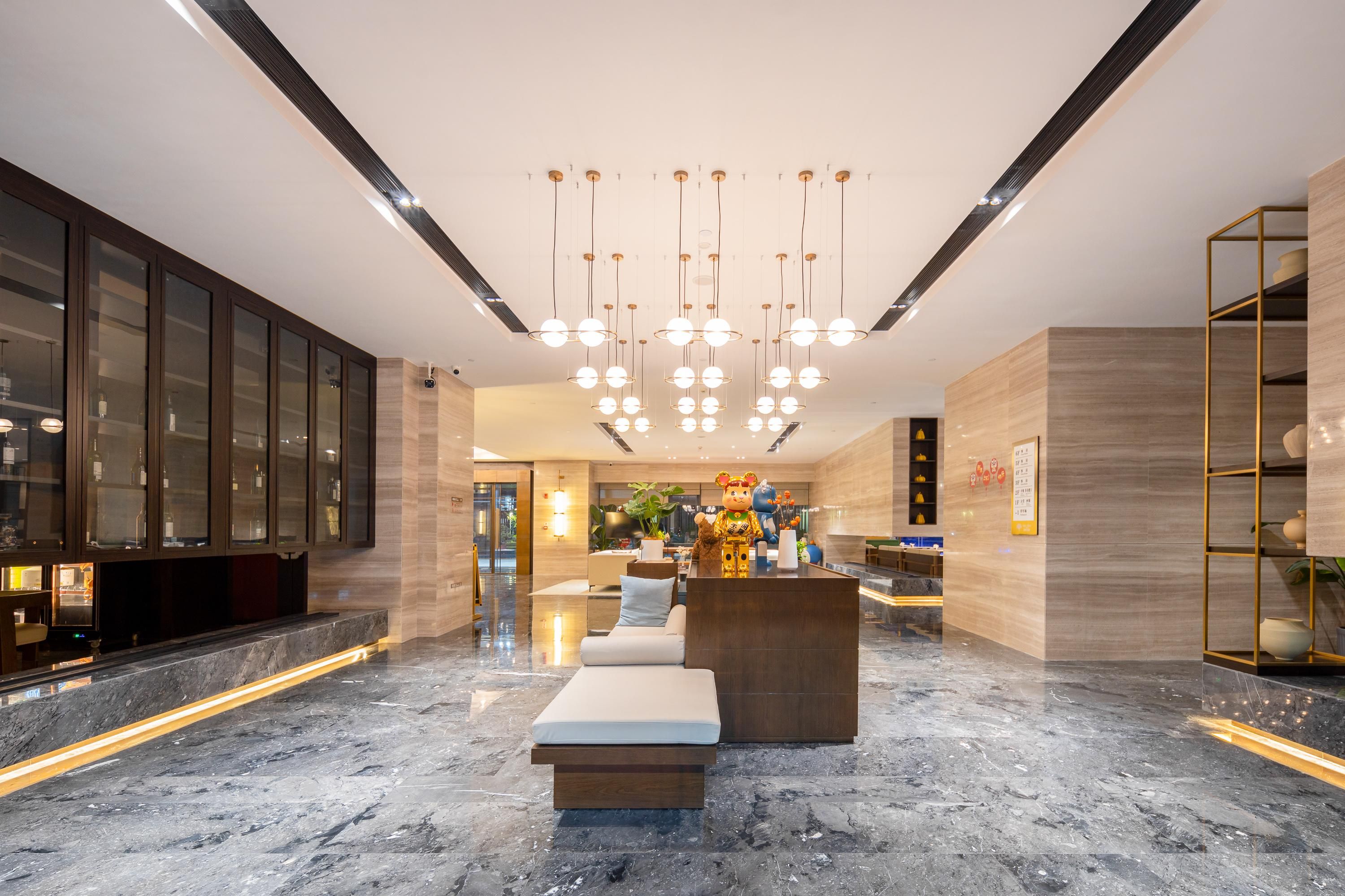 Um hall moderno com piso de mármore, balcão de recepção e área de estar.