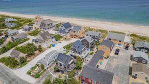 An aerial view of a coastal residential area with houses near a beach.