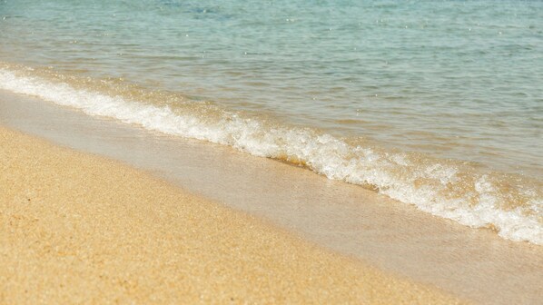 Una spiaggia sabbiosa con onde calme.