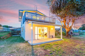 A modern two-story house with a balcony, a covered porch, and a large tree in the backyard. - Paradise in Waikawa Beach - Family and pet friendly - Home away from Home (Waikawa Beach)