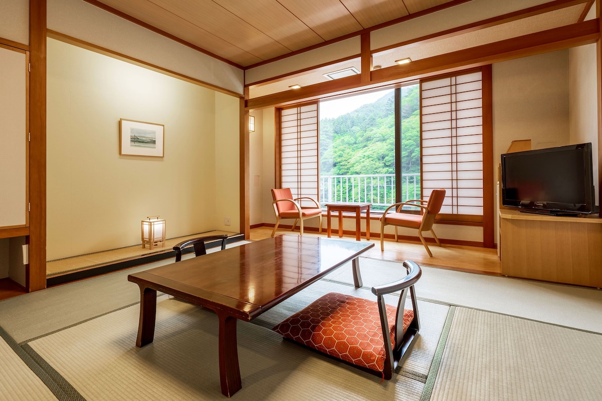 Een traditionele Japanse kamer met tatami vloerbedekking, een lage houten tafel en schuifdeuren van shoji papier.