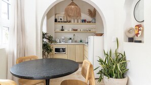 A modern kitchen with a round table, chairs, and a variety of plants. - Vallarta's lovely apartment (Puerto Vallarta)