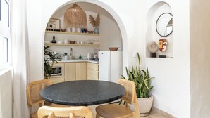 A compact kitchen with a round table and chairs, a hanging light fixture, and a mirror on the wall. - Vallarta's lovely apartment (Puerto Vallarta)