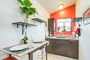 Een koelkast, een microgolfoven, kookgerei, borden en bestek, kruiden