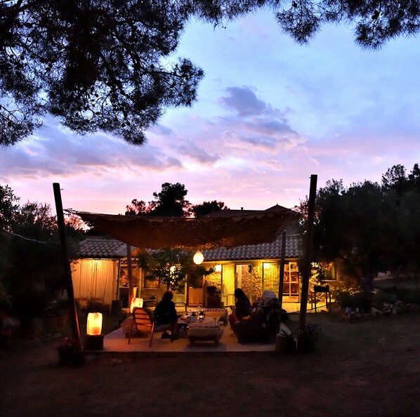 An outdoor seating area with a covered patio, a dining table, and chairs.