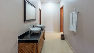 A modern bathroom with a wooden vanity, two sinks, and a mirror.