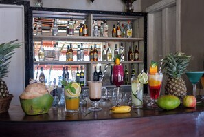 A bar with various drinks and fruits, including coconuts and pineapples. - Mandarin Resort Zanzibar (Kizimkazi)
