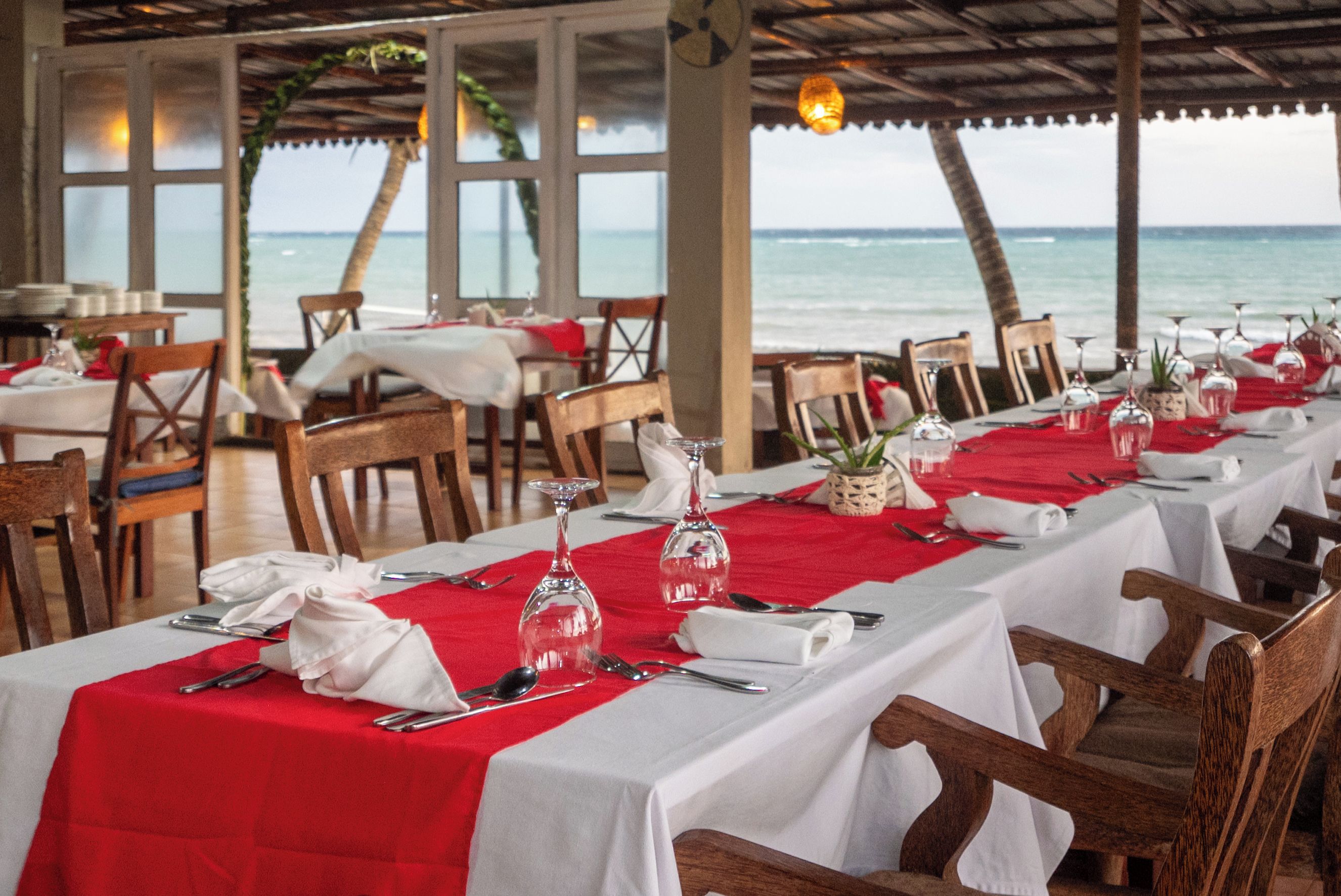 A restaurant with tables set for dining, overlooking the sea.